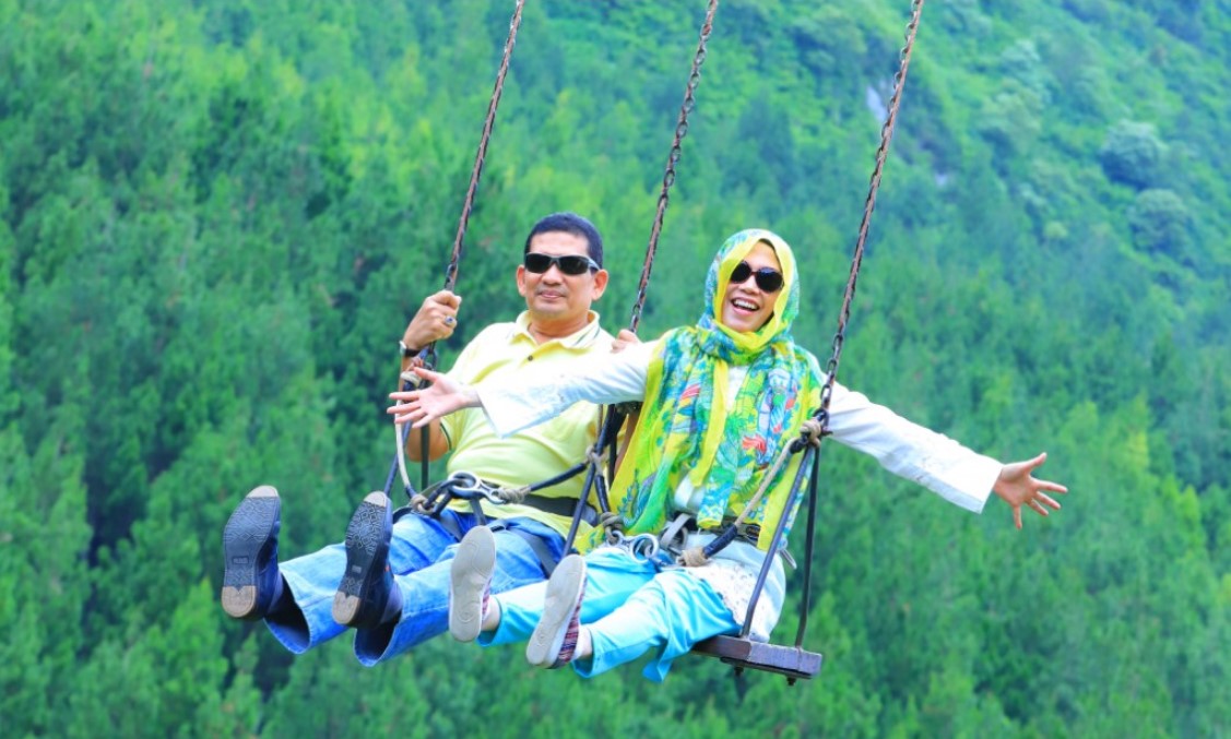 Wahana ayunan langit (sky swing) di The Lodge Maribaya dengan latar pegunungan